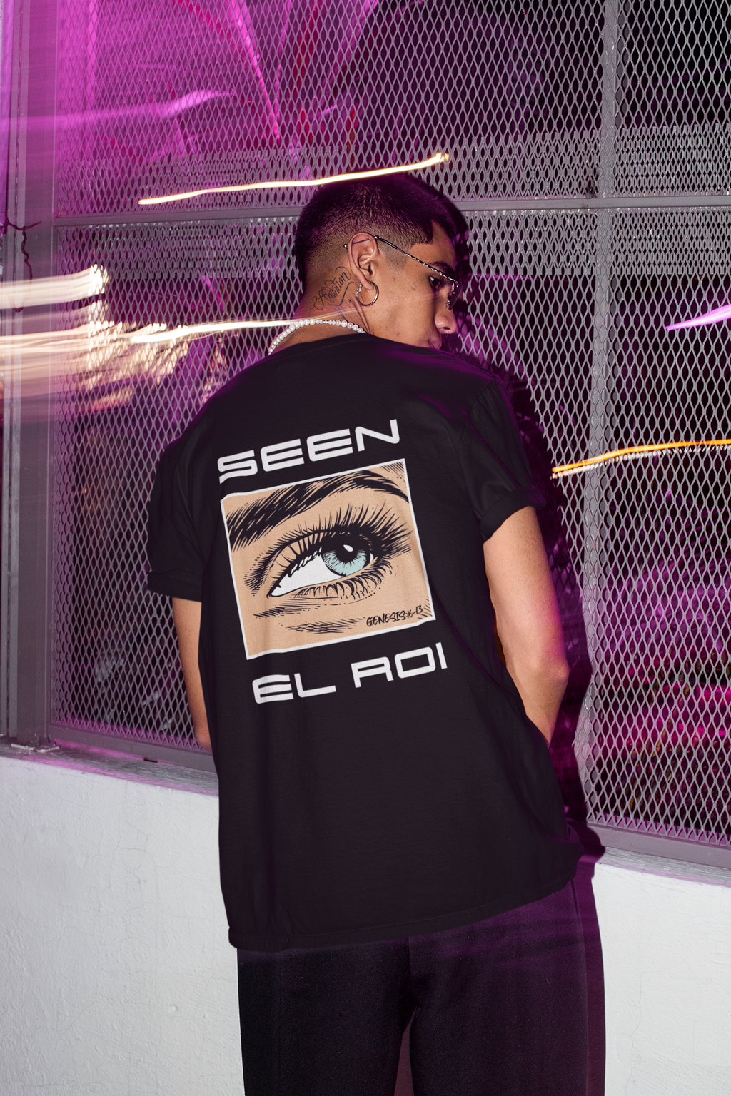 Black Christian graphic t-shirt featuring a detailed illustrated blue eye with the words "SEEN" and "EL ROI," referencing Genesis 16:13 and the biblical name for God meaning "The God Who Sees Me." Modern faith-based streetwear design displayed on black, blue, and olive green shirts.
